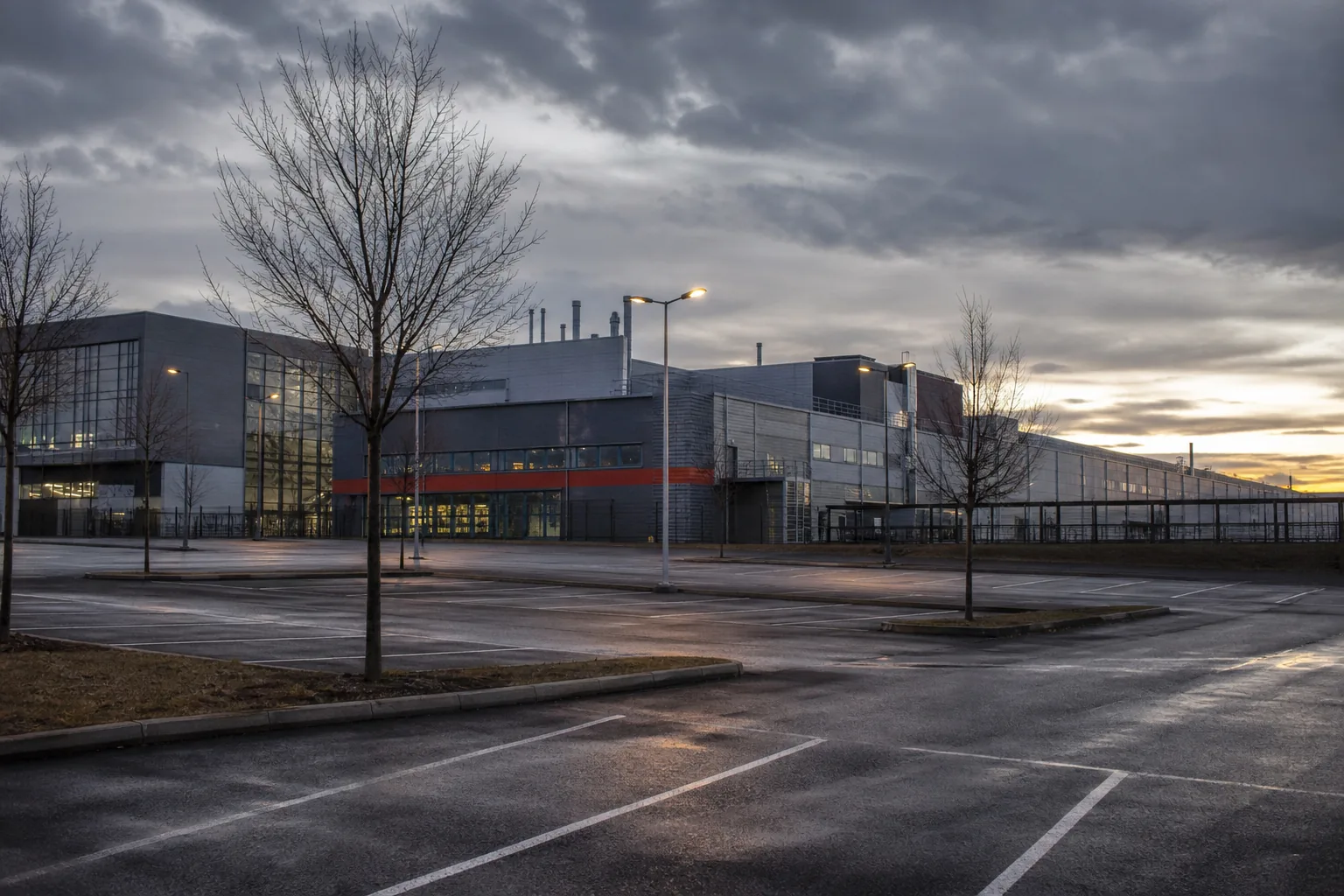Symbolbild: Ein Autowerk in gedämpfter Abendstimmung steht für den wachsenden Spardruck in der Branche.