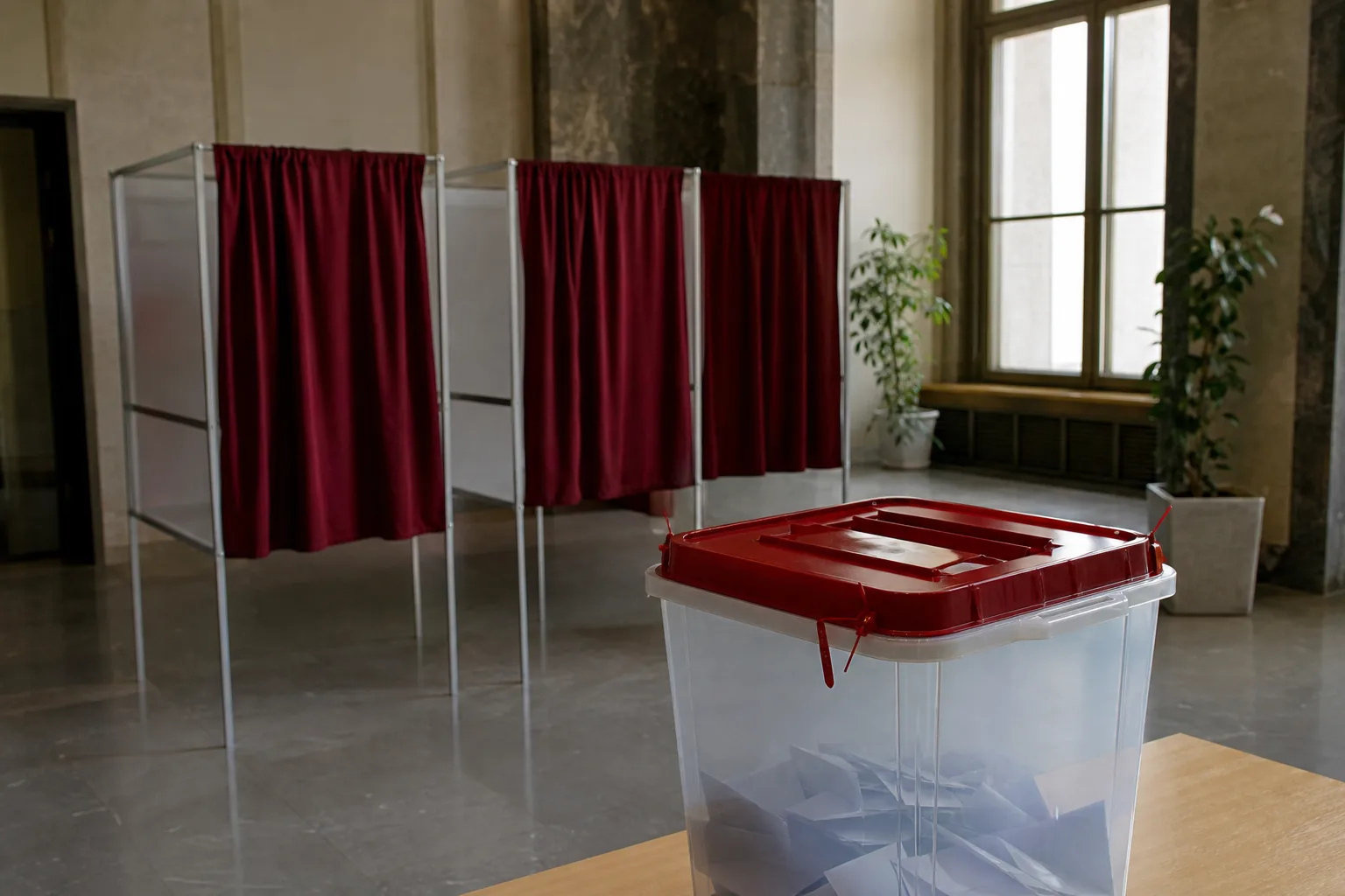 Symbolbild: Eine Wahlkabine und eine Urne stehen für die Parlamentswahl in Lettland.